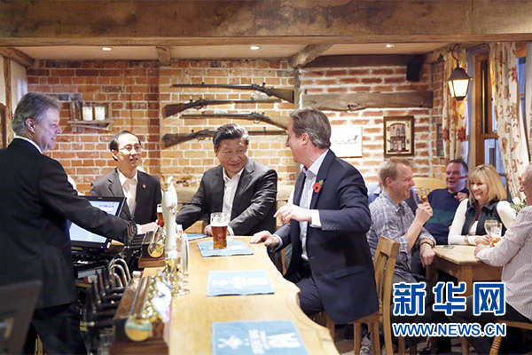 這是會(huì)晤結(jié)束后，習(xí)近平在卡梅倫陪同下乘車(chē)前往當(dāng)?shù)匦℃?zhèn)體驗(yàn)酒吧文化。新華社記者 鞠鵬 攝