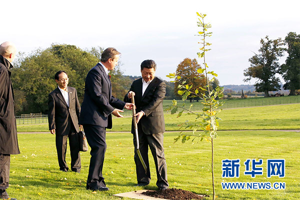 兩國(guó)領(lǐng)導(dǎo)人一同在別墅草坪，共同種下象征中英友誼的橡樹(shù)。新華社記者 鞠鵬 攝